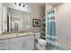 Bright bathroom features granite counters, white cabinets, and a shower with blue striped curtain at 420 E Fremont Pl # 309, Centennial, CO 80122
