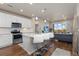 Bright eat-in kitchen featuring white cabinets, stainless steel appliances, and breakfast bar seating that overlooks the living area at 420 E Fremont Pl # 309, Centennial, CO 80122