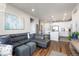 A stylish living room with hardwood floors, a modern gray sectional sofa, and an open layout leading to the kitchen at 420 E Fremont Pl # 309, Centennial, CO 80122