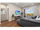 Cozy living area with wood floors, large windows with views, a gray couch, and a mounted flat screen television at 420 E Fremont Pl # 309, Centennial, CO 80122