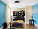 Bright home office with hardwood floors, custom shelving, and a modern adjustable desk at 2432 Champa St, Denver, CO 80205