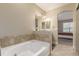 Bathroom with tub and tile, with view through archway into bedroom at 22163 E Calhoun Pl, Aurora, CO 80016