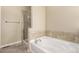 Bright bathroom featuring a white soaking tub and tiled walls at 22163 E Calhoun Pl, Aurora, CO 80016