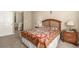Comfortable bedroom featuring wood furnishings and a patterned quilt, bathed in warm, neutral tones at 22163 E Calhoun Pl, Aurora, CO 80016