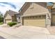 A tan house with a yellow garage door and a well-maintained lawn, perfect for suburban living at 22163 E Calhoun Pl, Aurora, CO 80016