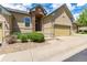 Charming tan home featuring a stone accented entryway, yellow garage door, and a beautifully maintained front yard at 22163 E Calhoun Pl, Aurora, CO 80016