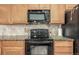 A well-equipped kitchen with stainless steel appliances, granite counters, and wood cabinets offers a practical cooking space at 22163 E Calhoun Pl, Aurora, CO 80016
