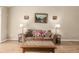 Comfortable living room featuring a brown sofa, decorative pillows, and classic artwork, perfect for relaxation at 22163 E Calhoun Pl, Aurora, CO 80016