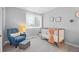 Bright Bedroom featuring a comfortable chair, a crib with neutral linens, and serene wall decor at 18126 E Alamo Dr, Centennial, CO 80015