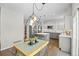 Modern kitchen and dining area featuring stainless steel appliances, center island, stylish light fixture, and dining table at 18126 E Alamo Dr, Centennial, CO 80015