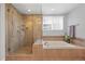 Lovely bathroom features a soaking tub, walk-in shower with glass doors and natural light at 18126 E Alamo Dr, Centennial, CO 80015
