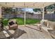 Relaxing back patio with wicker furniture and a well-manicured backyard, perfect for outdoor entertaining at 4762 S Clay Ct, Englewood, CO 80110