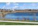 Scenic view of a tranquil lake surrounded by lush greenery and industrial skyline at 4762 S Clay Ct, Englewood, CO 80110