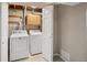 Functional laundry room featuring a washer, dryer, and cabinetry for storage solutions at 4762 S Clay Ct, Englewood, CO 80110