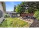 Landscaped backyard with patio, green grass, wooden fence, and outdoor seating at 886 S Jersey St, Denver, CO 80224