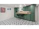 Basement featuring a black and white patterned floor and olive-green cabinets with wooden countertop at 886 S Jersey St, Denver, CO 80224