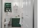 Bathroom featuring green vanity, open storage, white walls, and white tiled floors at 886 S Jersey St, Denver, CO 80224