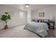 Bedroom featuring carpeted floors, a window, a plant and a bed with gray comforter at 886 S Jersey St, Denver, CO 80224