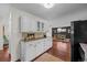 Kitchen showcasing ample counter space, white cabinets, a view of the dining area, and rich hardwood flooring at 886 S Jersey St, Denver, CO 80224