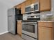 Well-equipped kitchen with stainless steel appliances, granite counters, and wood cabinets at 7835 Barbara Ann Dr # C, Arvada, CO 80004