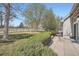 Well-maintained backyard with lush grass, mature trees, and a secure black metal fence at 8300 Fairmount Dr # J105, Denver, CO 80247