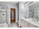 Bathroom with a double sink vanity, large mirror, and walk-in shower at 8300 Fairmount Dr # J105, Denver, CO 80247