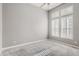 A primary bedroom with neutral walls, carpet, ceiling fan, and large window with plantation shutters at 8300 Fairmount Dr # J105, Denver, CO 80247