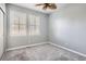 Bedroom with neutral walls, carpet, ceiling fan, and a bright window with plantation shutters at 8300 Fairmount Dr # J105, Denver, CO 80247