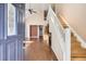 Bright entryway showcasing hardwood floors, a staircase, and an open view into the living space at 8300 Fairmount Dr # J105, Denver, CO 80247