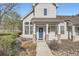 Home featuring a blue front door, stone accents, landscaping, and large windows with white shutters at 8300 Fairmount Dr # J105, Denver, CO 80247