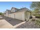 Attached two-car garage in multi-unit townhome featuring neutral paint, asphalt roof, concrete driveway, and gravel landscaping at 8300 Fairmount Dr # J105, Denver, CO 80247