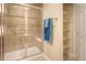 Shower stall with glass door and shelving unit with towels, adjacent to a white door at 8594 W Quarto Ave, Littleton, CO 80128