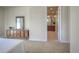 Light-filled bedroom featuring neutral walls, a dresser with mirror, and an en-suite bathroom with a double vanity at 8594 W Quarto Ave, Littleton, CO 80128