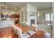 Dining room flowing into open kitchen with hardwood floors and a fireplace in view at 8594 W Quarto Ave, Littleton, CO 80128