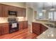 Inviting kitchen featuring stainless steel appliances, granite countertops, plenty of cabinet space, and warm lighting at 8594 W Quarto Ave, Littleton, CO 80128