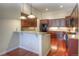 Modern kitchen featuring granite countertops, wood cabinets, stainless steel appliances, and hardwood floors at 8594 W Quarto Ave, Littleton, CO 80128