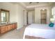 Spacious main bedroom with light-colored walls, carpeted floors, and a stylish dresser with a decorative mirror at 8594 W Quarto Ave, Littleton, CO 80128