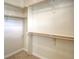 Carpeted walk-in closet featuring light-colored walls and wooden shelving and rods, offering ample storage at 8594 W Quarto Ave, Littleton, CO 80128