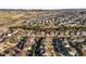 High angle view showcases a neighborhood with varied home styles, nestled amidst trees, with mountains in the background at 1271 Sky Rock Way, Castle Rock, CO 80109