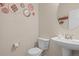 Small bathroom featuring a pedestal sink, toilet, and stylish decor at 1271 Sky Rock Way, Castle Rock, CO 80109