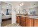 Elegant bathroom with double sinks, tiled countertops, and easy access to the bedroom at 1271 Sky Rock Way, Castle Rock, CO 80109