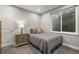 A bedroom has a garden-level window for natural light, bedside table, and neutral color scheme at 1271 Sky Rock Way, Castle Rock, CO 80109