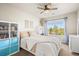 Bright bedroom with a large window with outdoor views, white furniture and a contrasting white shelving unit with blue storage bins at 1271 Sky Rock Way, Castle Rock, CO 80109