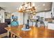 Dining room with wooden table, modern chandelier, and open floor plan flowing into the kitchen area at 1271 Sky Rock Way, Castle Rock, CO 80109