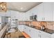 Elegant kitchen featuring granite counters, stainless steel appliances, and sleek white cabinetry at 1271 Sky Rock Way, Castle Rock, CO 80109
