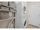 Functional laundry room with stacked washer and dryer units, built-in shelving, and ample storage space at 1271 Sky Rock Way, Castle Rock, CO 80109