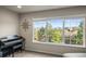 Bright living room featuring a piano and scenic views from the large windows at 1271 Sky Rock Way, Castle Rock, CO 80109