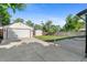 Spacious backyard featuring a detached garage, storage shed, and a large concrete pad, perfect for outdoor activities at 5640 Niagara St, Commerce City, CO 80022