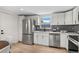 Bright kitchen featuring stainless steel appliances, white cabinetry, and a stylish gray subway tile backsplash at 5640 Niagara St, Commerce City, CO 80022