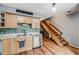 Bright kitchen with stainless steel appliances, wood cabinets, stylish backsplash, and staircase at 1150 Inca St # 43, Denver, CO 80204